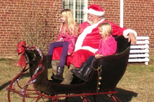 "Santa", Wallace Mahanes, and children on his sleigh.